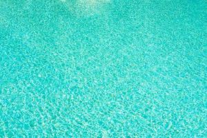 fundo de água na piscina azul, superfície da água com reflexo do sol foto