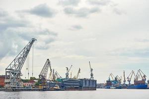 ponte de guindaste de trabalho em estaleiro e navios de carga em um porto foto