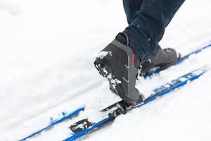 pés de um esquiador em botas de esqui em esquis cross-country. andando na neve, esportes de inverno, estilo de vida saudável. close-up, copyspace foto