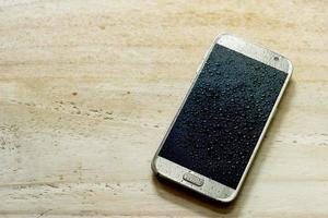 closeup smartphone molhado cai no chão de madeira foto