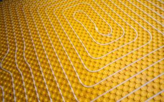 instalação de piso radiante amarelo com tubos brancos foto