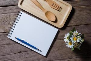 caderno aberto com bandeja de madeira na mesa foto