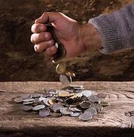 mãos do homem caucasiano e pilha de moedas antigas