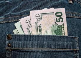 dólares americanos no bolso de trás da calça jeans foto