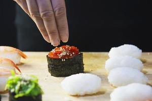 rolo de sushi maki japonês servindo no restaurante oriental, o chef está preparando o menu de culinária da tradição japonesa, vários conceitos de conjunto de alimentação saudável misto de luxo sortido diferente foto