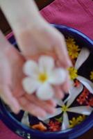 mão feminina e flor na água foto