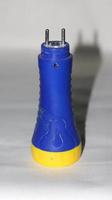 lanterna led, alça azul e amarela, cabeça da tocha é plástico branco close-up de uma lanterna isolada no fundo branco foto