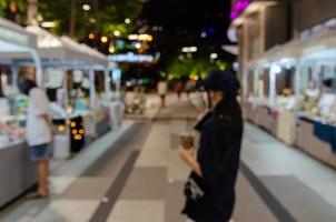 borrão fundo resumo povo compras noturnos mercado street food festival defocused. foto