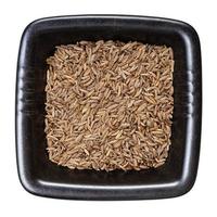 vista superior de sementes de alcaravia em tigela preta isolada foto