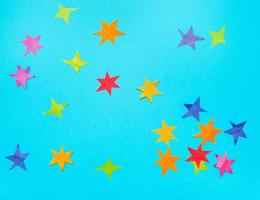 estrelas multicoloridas cortadas de papéis em papel azul foto