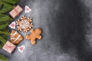 pão de gengibre, enfeites de árvore de natal, frutas cítricas secas em um fundo cinza de concreto foto