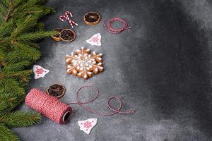 pão de gengibre, enfeites de árvore de natal, frutas cítricas secas em um fundo cinza de concreto foto