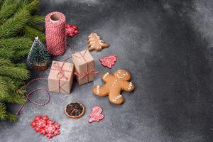 pão de gengibre, enfeites de árvore de natal, frutas cítricas secas em um fundo cinza de concreto foto