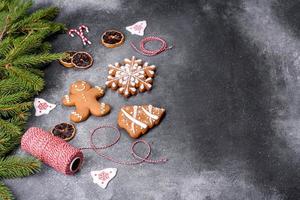 pão de gengibre, enfeites de árvore de natal, frutas cítricas secas em um fundo cinza de concreto foto