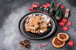 pão de gengibre, enfeites de árvore de natal, frutas cítricas secas em um fundo cinza de concreto foto