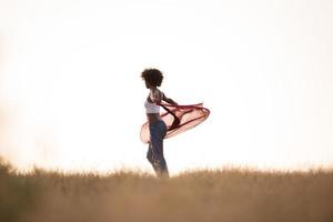 garota negra dança ao ar livre em um prado foto