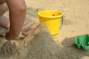 castelo de areia de construção infantil na praia foto