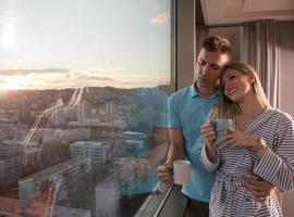 jovem casal desfrutando de café à noite pela janela foto