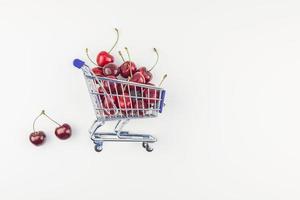 cerejas maduras em um carrinho de compras isolado foto