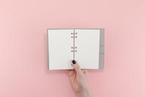 mãos de mulher com maquete de bloco de notas em branco foto