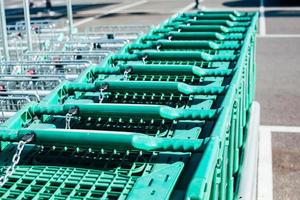 linha de carrinhos de compras verdes em um supermercado foto