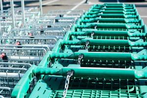 linha de carrinhos de compras verdes em um supermercado foto