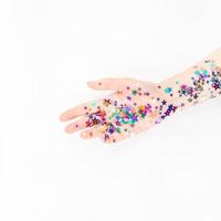 mão de mulher com confete estrela de cor festiva foto