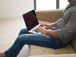 homem usando laptop na sala de estar foto