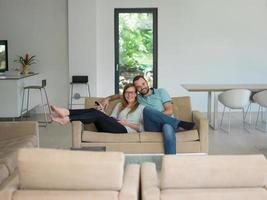 jovem casal no sofá assistindo televisão foto