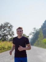 homem correndo ao longo de uma estrada rural foto