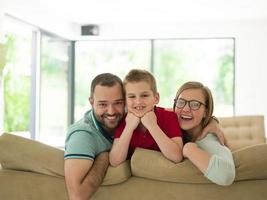 família com menino gosta na moderna sala de estar foto