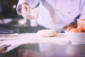 mãos de chef preparando massa para pizza foto