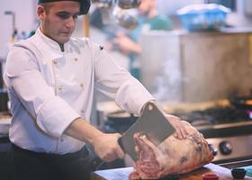 chef cortando grande pedaço de carne foto