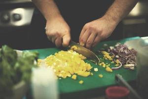 mãos de chef cortando legumes frescos e deliciosos foto