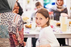 menina bonitinha desfrutando do jantar iftar com a família foto