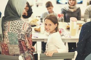 menina bonitinha desfrutando do jantar iftar com a família foto