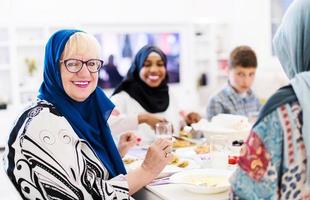 avó muçulmana moderna desfrutando do jantar iftar com a família foto