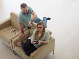 casal relaxando em casa com computadores tablet foto