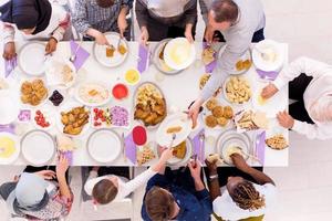 vista superior da família muçulmana multiétnica moderna tendo um banquete do ramadã foto