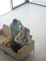 casal relaxando em casa com computadores tablet foto