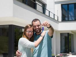 casal se abraçando em frente a nova casa de luxo foto