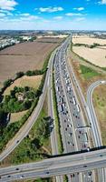 bela vista aérea das autoestradas britânicas movimentadas com tráfego e cidade em um dia ensolarado foto
