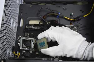 imagem de um técnico inserindo um chip de CPU em uma placa-mãe de computador. foto