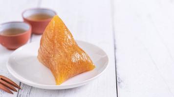 bolinho de arroz alcalino zongzi - comida de cristal chinesa doce tradicional em um prato para comer para o conceito de celebração do festival do barco dragão duanwu, close-up. foto