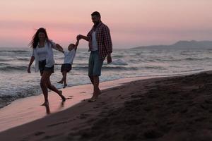 a família aproveita as férias enquanto caminham pela praia com o filho. foco seletivo foto