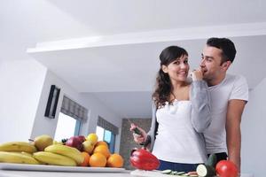 jovem casal se diverte na cozinha moderna foto