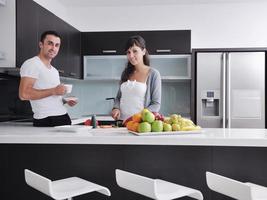 jovem casal se diverte na cozinha moderna foto