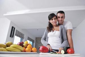 jovem casal se diverte na cozinha moderna foto