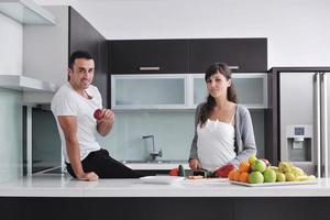 jovem casal se diverte na cozinha moderna foto