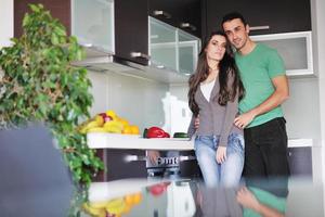 jovem casal se diverte na cozinha moderna foto